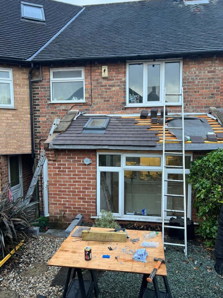 This is a photo of a roof extension that is having new roof tiles installed. This is a photo taken from the roof ridge looking down a tiled pitched roof on to a flat roof. Works carried out by Kirkby in Ashfield Roofing Repairs