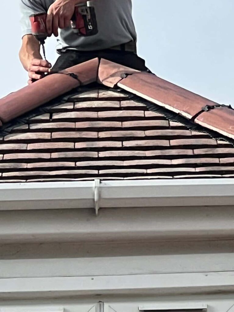 This is a photo of one of the operatives of Kirkby in Ashfield Roofing Repairs installing new ridge tiles